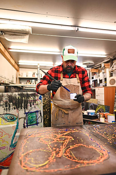 Artist carefully applying paint to canvas in studio