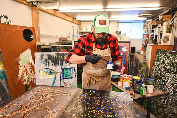 Artist carefully painting in his messy art studio workshop