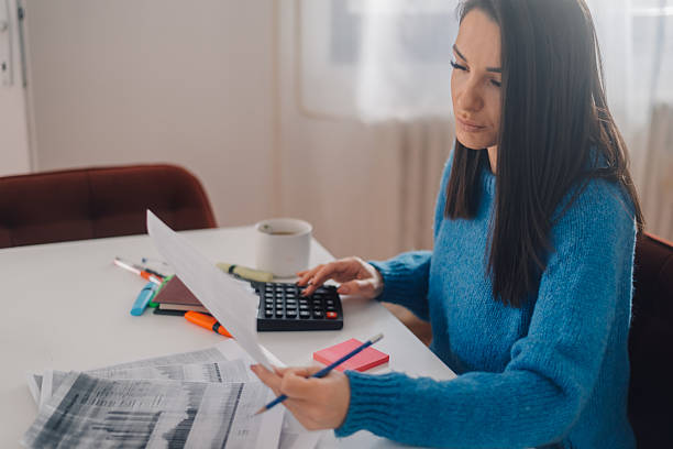 istock Accountant calculating domestic bills at home office using calculator and checking receipts 2225618763