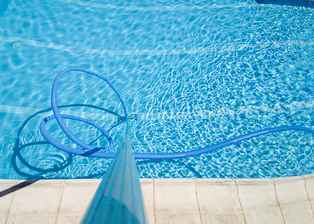 istock Worker cleaning and vacuuming the bottom of the pool 2225620988