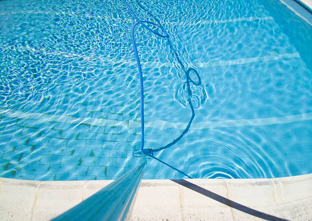istock Worker cleaning and vacuuming the bottom of the pool 2225621003