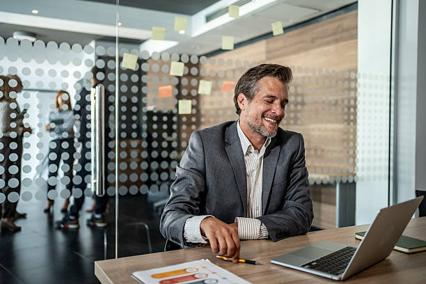 istock Smiling businessman working on laptop in modern office 2225621793