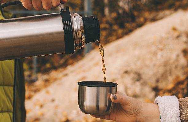 istock In autumn, warm, warming, delicious tea from a thermos is poured into a glass 2225625183