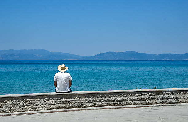 istock Man in Hat Sitting by the Sea 2225626767
