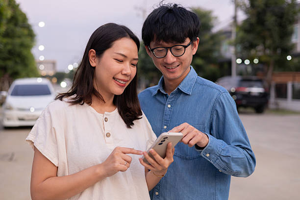 istock close up group of asian couple lover check notification from smartphone together while stay outside for searching about location or destination for lifestyle cocnept 2225627021