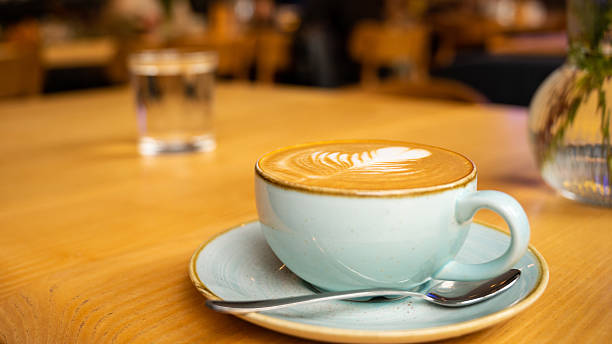 istock Latte with rosetta art in ceramic cup on wooden table in cafe 2225627180