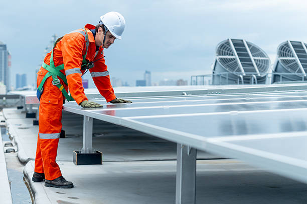 istock Technician or factory worker man bend body and look to  maintenance rooftop solar cell system with cloudy sky. 2225627676