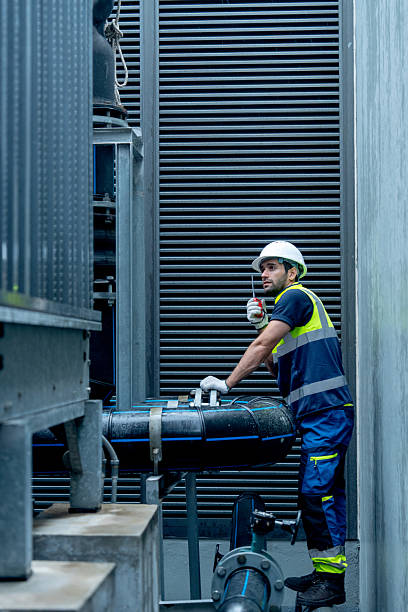 istock Vertical image of engineer or technician worker hold  walkie talkie and stand with looking and maintenance during work with steel pipe system of factory building. 2225627989