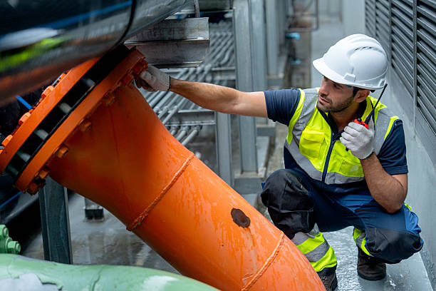 istock Side view of engineer or technician worker use walkie talkie to contact co-worker  during work with steel pipe system of factory building. 2225627994