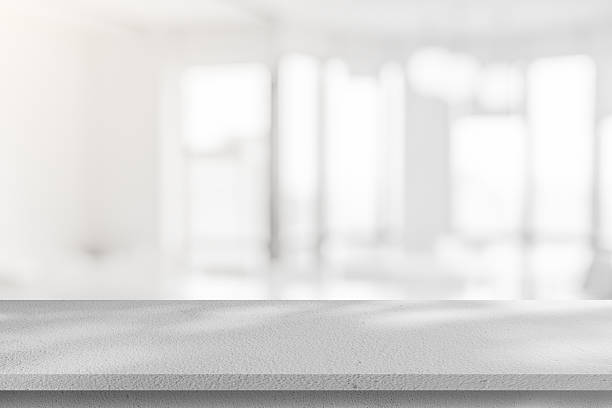 istock Abstract blurred interior modern office room background with perspective white cement table for show, promote and design content or product on display concept 2225629939