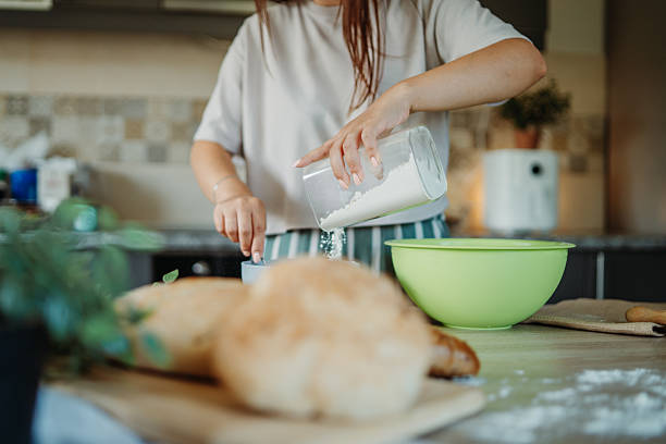 istock Young caucasian woman making bread dough in her kitchen 2225631934