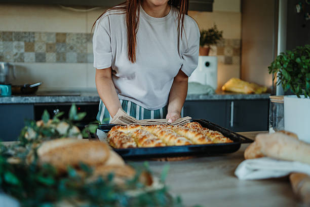 Young caucasian woman making bread dough in her kitchen