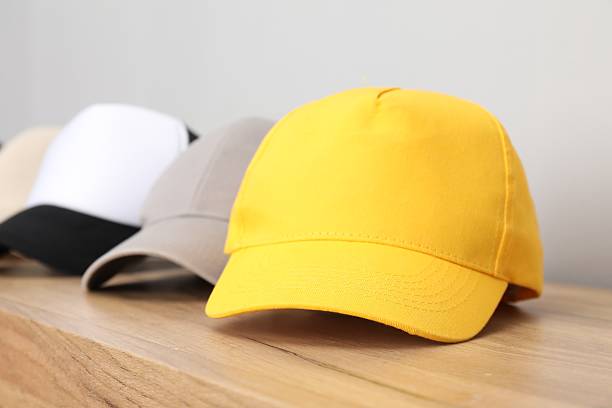 istock Stylish baseball caps on wooden table, closeup. Mockup for design 2225632548