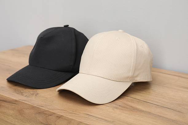istock Stylish baseball caps on wooden table. Mockup for design 2225632608