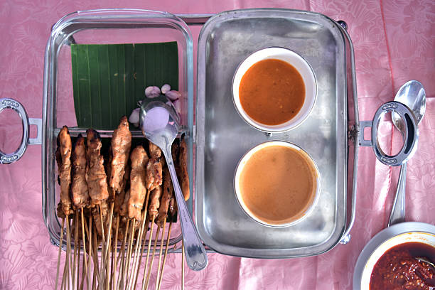 Flat lay view of chicken satay with peanut sauce served in a buffet lunch. Self-service catering menu for small parties.