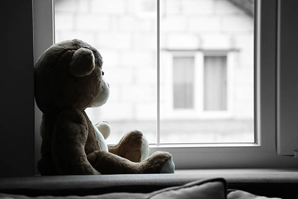 istock Lonely teddy bear near window. Space for text 2225635138