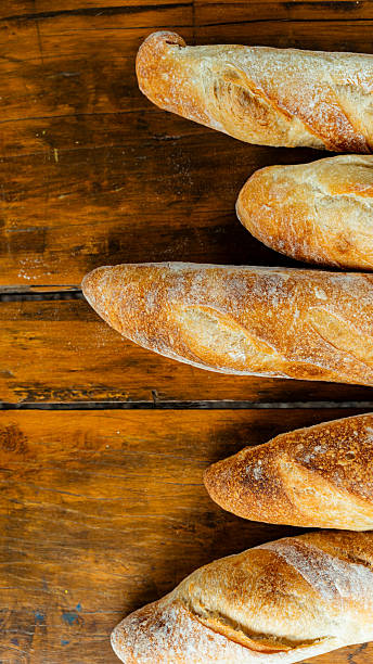 Freshly baked baguettes resting on rustic wooden table
