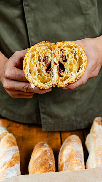 Baker holding a delicious pain au chocolat filled with chocolate