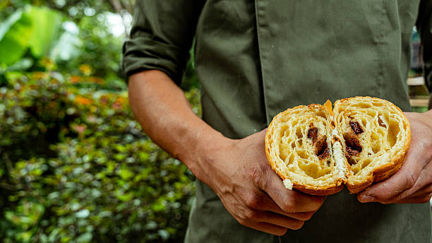 Baker holding a delicious pain au chocolat split in half