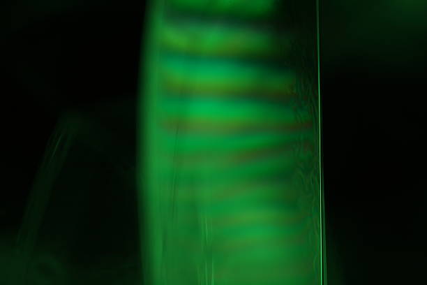 istock Green liquid edge on dark background, reflections of liquid in macro 2225640782