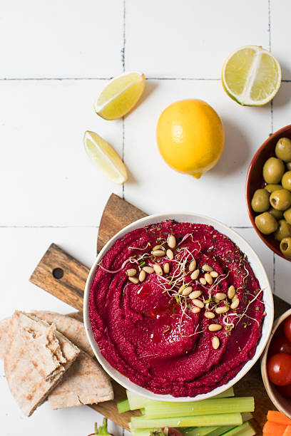 istock Beetroot hummus in a bowl on a board with fresh vegetables, celery, carrots, pita. Copy space 2225642897