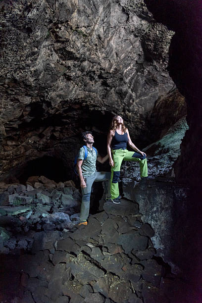 A couple sharing a moment of awe and discovery while exploring a magnificent natural cave. Travel Concept