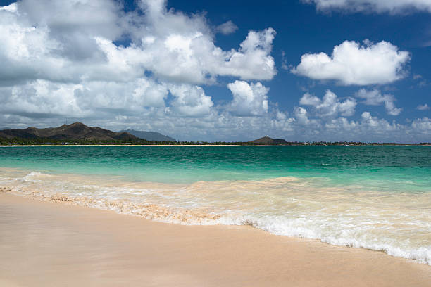 Tropical beach with white sand and turquoise water. White clouds against a blue sky