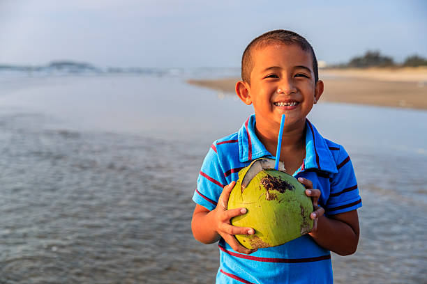 istock Vietnamese boy holding coconut on the beach, Vietnam 2225645502