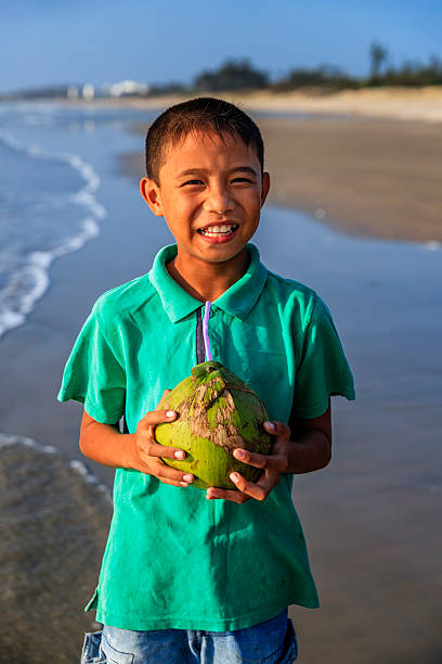 istock Vietnamese boy holding coconuts on the beach, Vietnam 2225645887