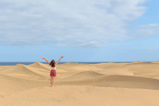 istock Joyful figure among sandy waves and blue skies 2225648617