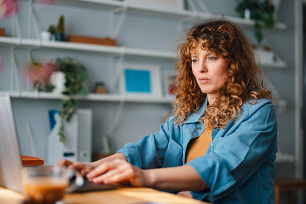 istock Woman Working on Laptop in a Cozy Home Office Setting 2225649003