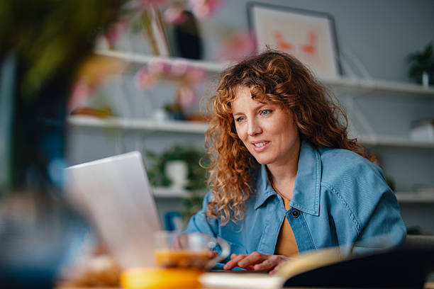 istock Smiling Woman Working on Laptop in a Comfortable Home Office Environment 2225649012