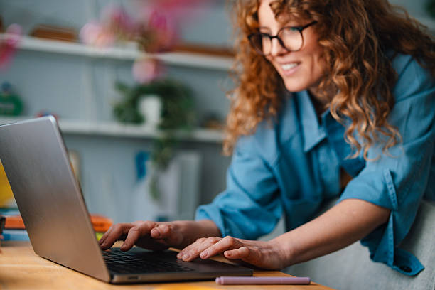 istock Smiling Woman Working From Home in a Bright Living Room Setting 2225649058