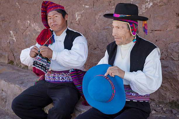 One man sewing a hat and another man knitting a hat, Taquile Island, Peru.Taquile is an island on the Peruvian side of Lake Titicaca 45 km offshore from the city of Puno. About 1,700 people live on the island, which is 5.5 by 1.6 km in size (maximum measurements), with an area of 5.72 km2. The highest point of the island is 4050 meters above sea level and the main village is at 3950 m. The inhabitants, known as Taquilenos, are southern Quechua speakers. Taquilenos run their society based on community collectivism  and on the Inca moral code ama sua, ama llulla, ama qhilla, (Quechua for \