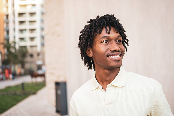 istock Young man smiling and looking away in urban setting 2225649872