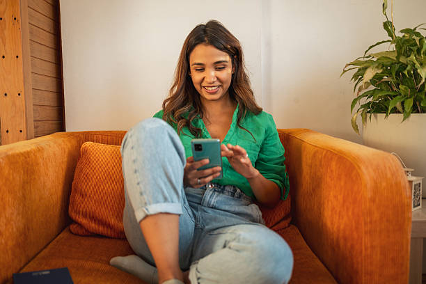 istock Young woman relaxing on sofa using smartphone at home 2225650252