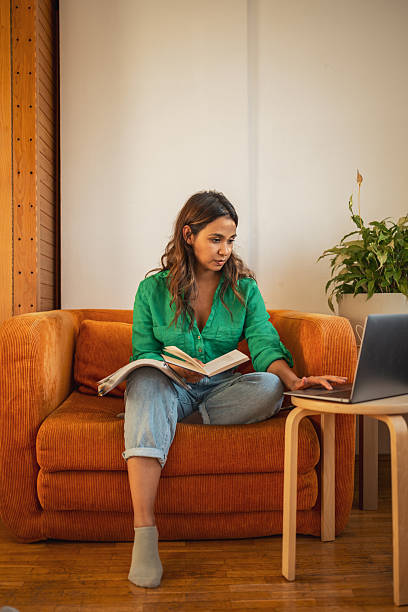 istock Young woman studying at home with laptop and book 2225650256