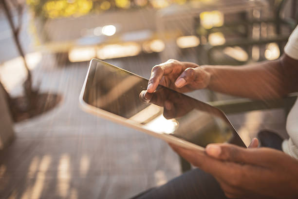 istock Young businessman using digital tablet outdoors in a cafe 2225650399