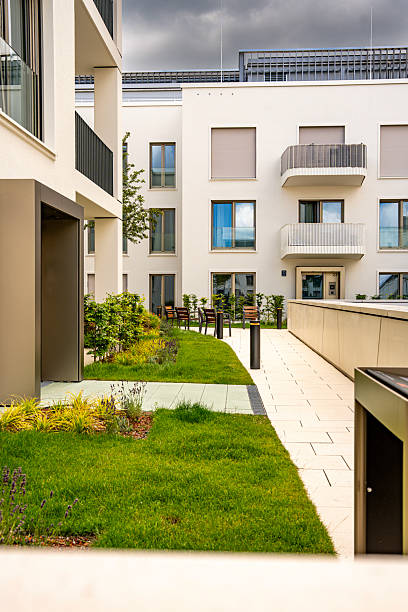 istock Modern Architecture In Freiham Munich Bavaria: Minimalist Building With Geometric Facade, Large Windows, And Small Tree In Courtyard Under Cloudy Sky 2225650590