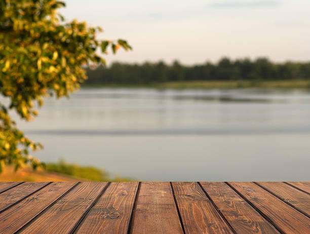 istock Serene lakeside view with wooden deck in focus 2225651610