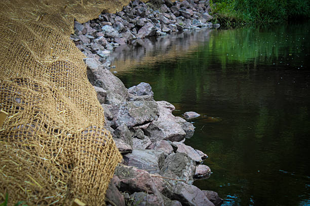 a bank stabilization project along a beautiful creek. watershed restoration with riprap and an erosion control mat
