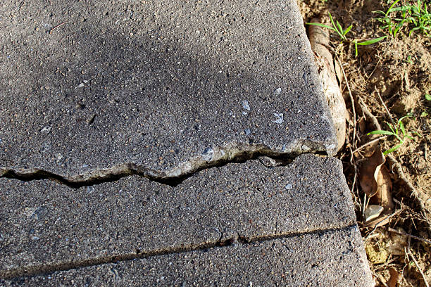 istock a sidewalk concrete slab that is lifted at a slight angle with a long crack due 2225651635