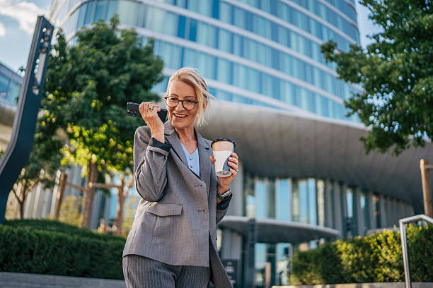 istock Businesswoman leaving voice message while holding coffee outside office 2225654562