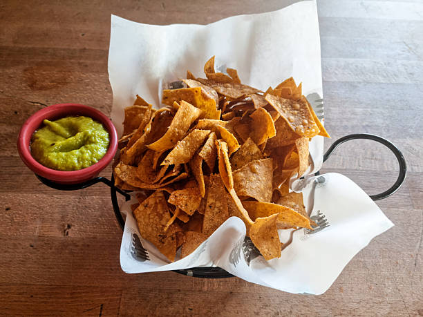 Guacamole and nachos chips on wooden table
