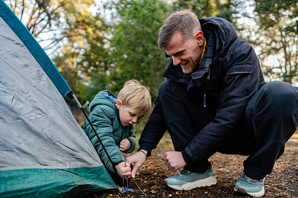 Father and son setting up a tent outdoors in Patagonia, Argentina