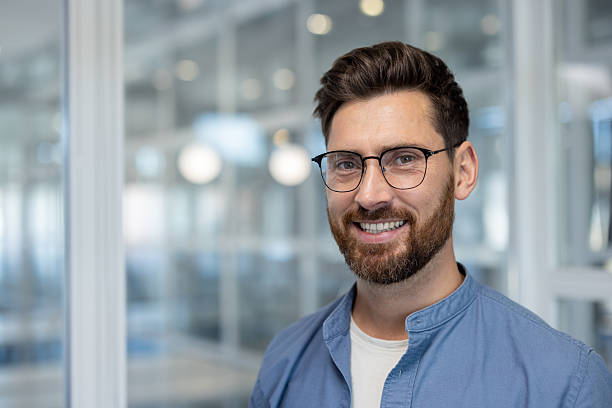 istock Smiling businessman with glasses looking directly at the camera in an office setting. 2225667242