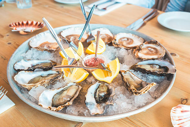 istock Fresh oysters with lemon and mignonette sauce served on ice 2225671113