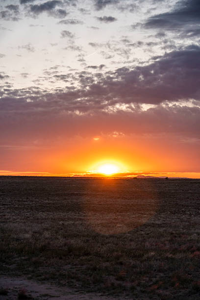 istock The sun sets over a vast field with a colorful sunset 2225671656