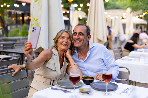 istock Senior couple taking a selfie while having dinner at a restaurant 2225673099