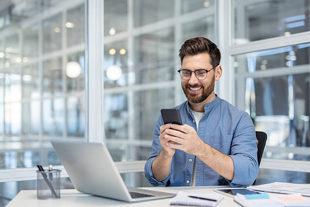 istock Happy businessman using his smartphone while working in a modern office. 2225681051